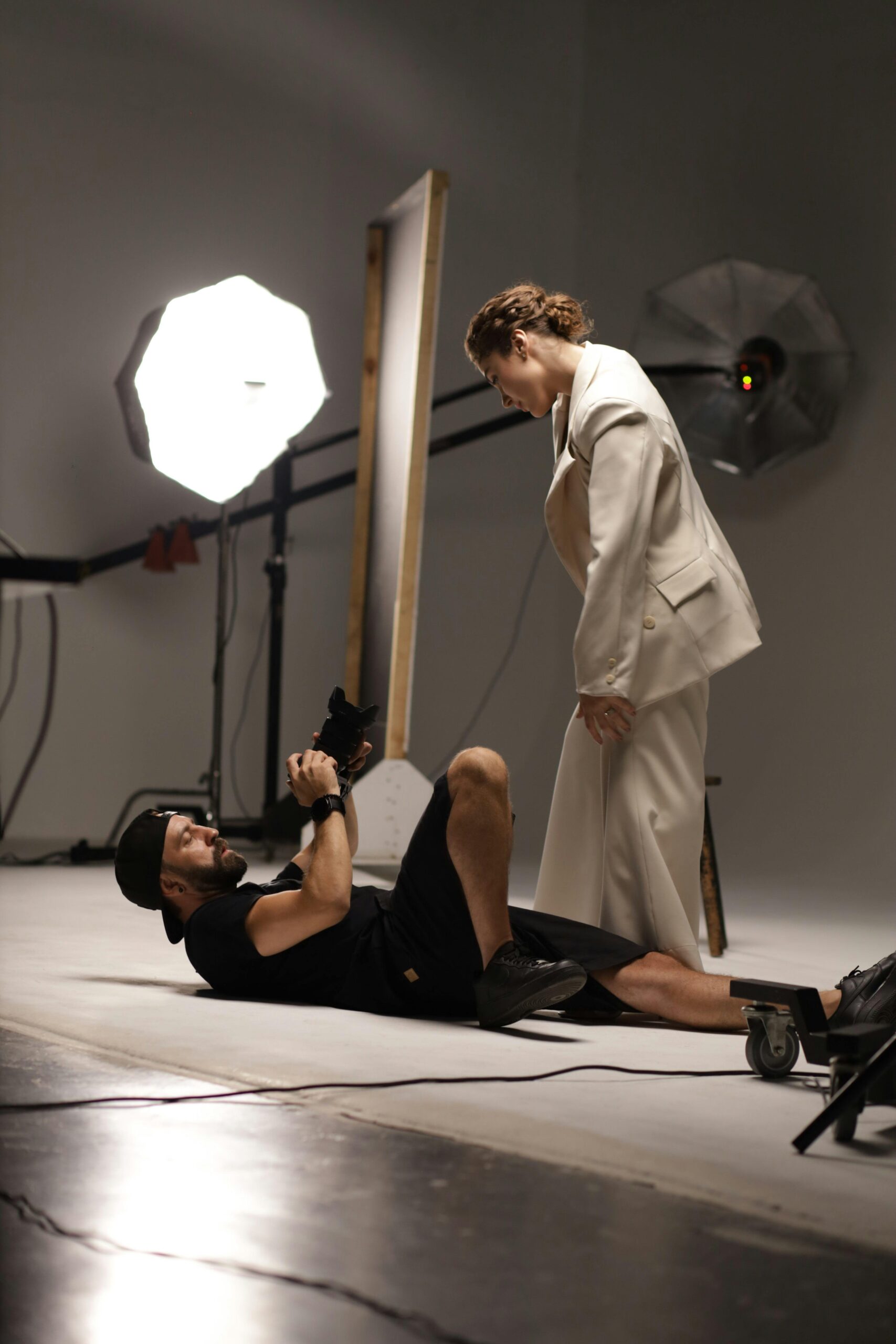 Contemporary studio shoot featuring a photographer capturing a model in elegant attire.