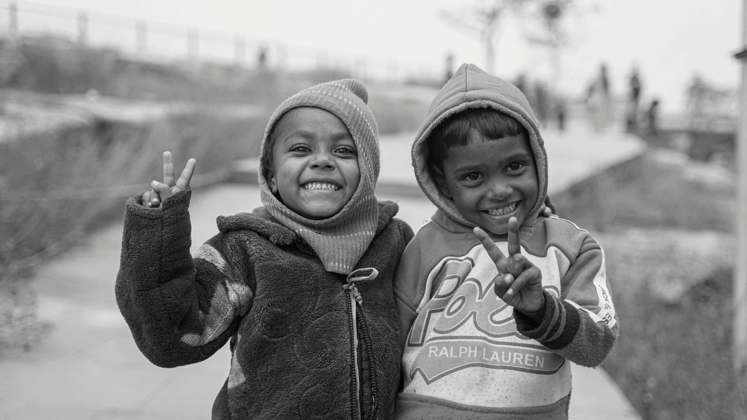 Two smiling children pose outdoors, capturing the essence of joy and carefree childhood.